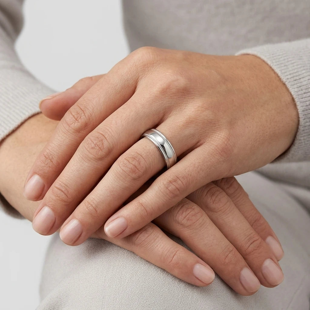 Enhanced Close-up of a 6mm stainless steel wedding ring with milgrain detailing and polished finish.  