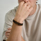 Men's bracelet stack with matte brown leather, polished black steel, and natural Tiger Eye stones  