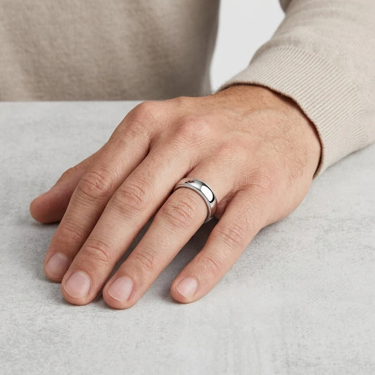 Enhanced Close-up of a polished 6mm stainless steel wedding band with milgrain edges and a domed profile  