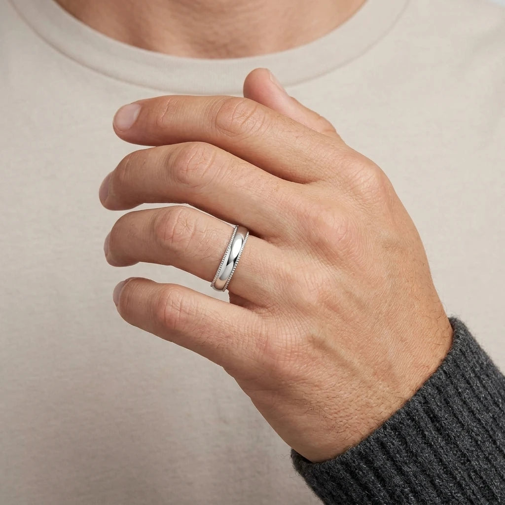 Enhanced Close-up of a polished stainless steel 4mm domed wedding band with detailed milgrain edges  