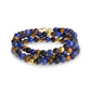 Side angle view of triple row men's bead bracelet showcasing the mix of matte black onyx, blue lapis lazuli, brown tiger eye, and hammered gold steel beads with clasp.
