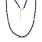 Extended view of men's beaded necklace made from matte black onyx, lapis lazuli, tiger eye, and gold hammered steel beads with gold lobster clasp and chain extension.