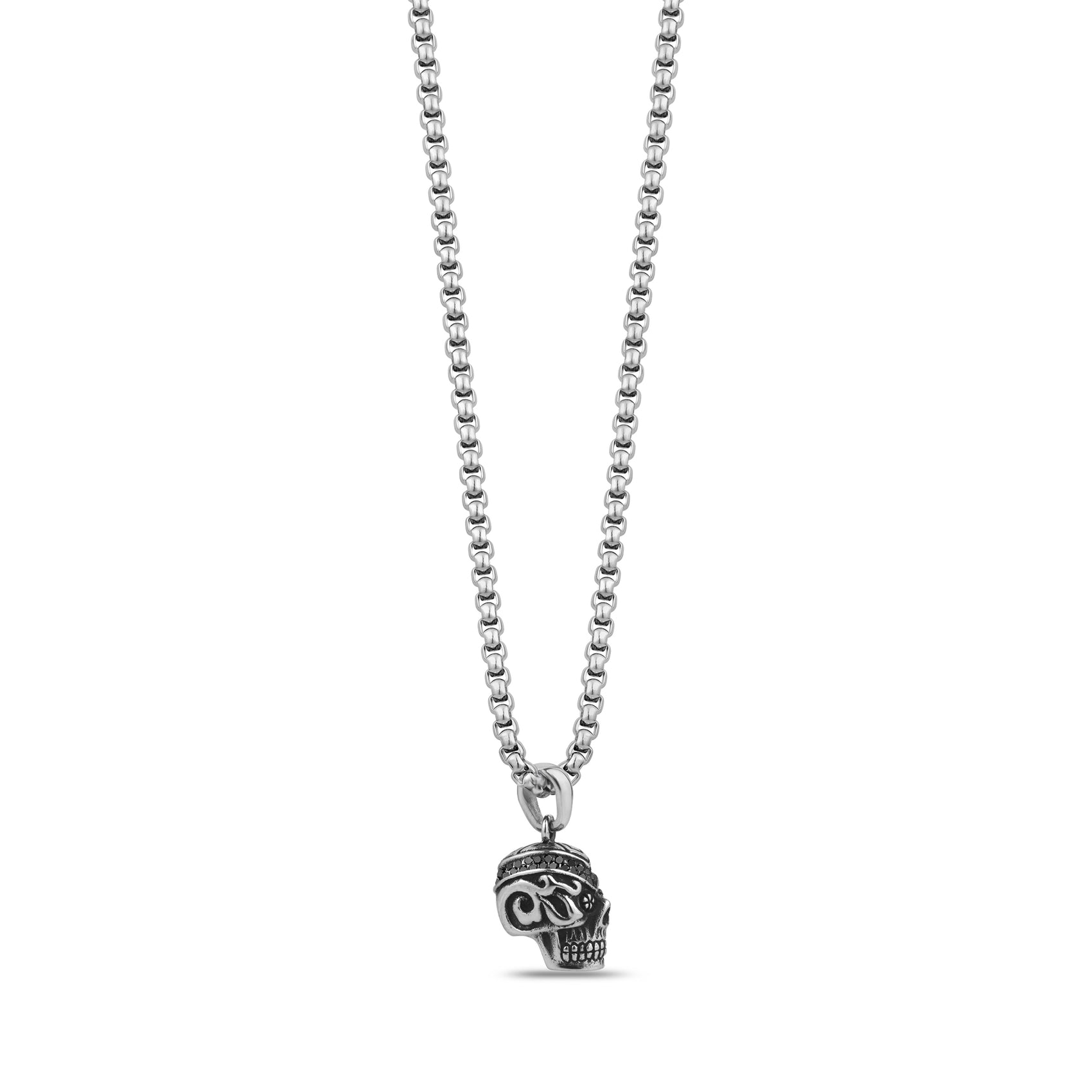Side angle view of engraved skull pendant necklace highlighting swirl and floral etchings with black detailing on temple