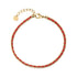 Gold-tone stainless steel woven cord bracelet with red thread and lobster clasp, showing adjustable chain and polished beads