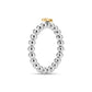 Top view of a round beaded stainless steel ring featuring a gold star accent