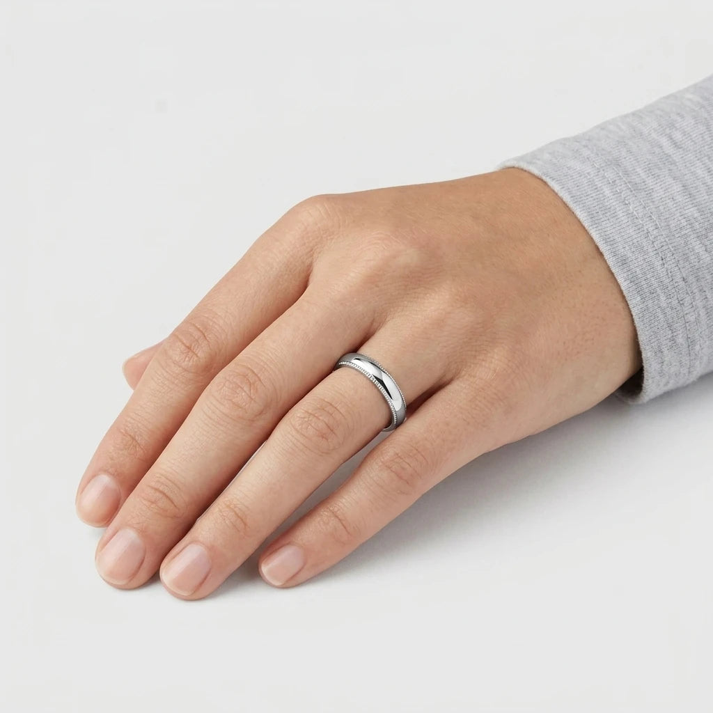 Enhanced Close-up of a polished stainless steel 4mm domed wedding band with detailed milgrain edges  