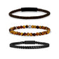 Stylish stack of three men's bracelets combining smooth leather, semi-precious stones, and steel  